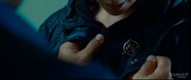 Mockingjay Pin The Hunger Games Wiki prim-is-wearing-the-mockingjay-pin-in-the-1st-trailer-at-the-reaping